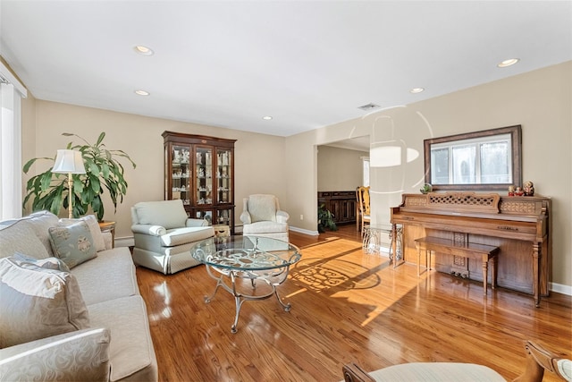 living room with light wood-type flooring, a healthy amount of sunlight, visible vents, and recessed lighting