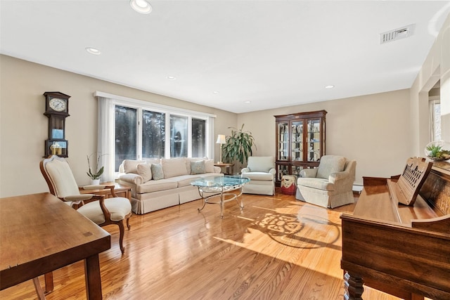 living area featuring light wood-type flooring, visible vents, and a healthy amount of sunlight