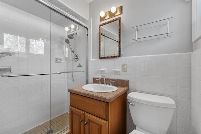 full bath featuring tile walls, toilet, a shower stall, and vanity