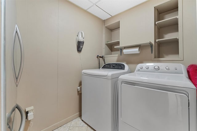 laundry room featuring washer and dryer, laundry area, and light tile patterned flooring