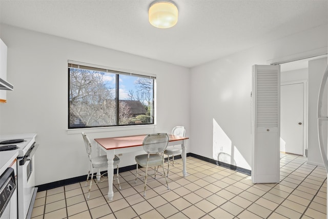 home office with light tile patterned floors, a textured ceiling, and baseboards