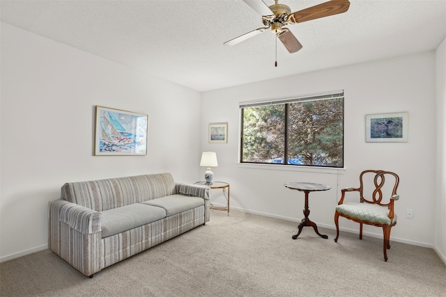 living area featuring carpet, baseboards, and a textured ceiling