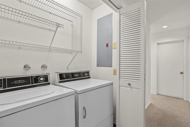 clothes washing area with light carpet, laundry area, electric panel, and washer and clothes dryer