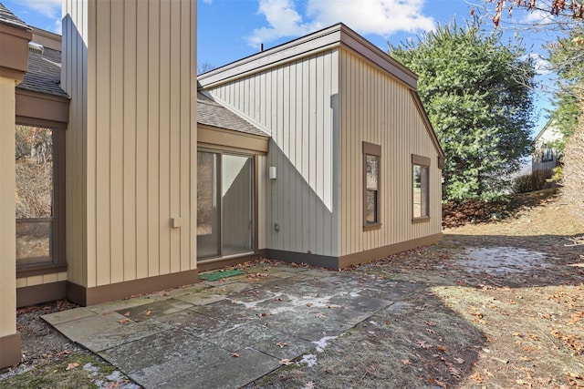 view of home's exterior featuring a patio area and roof with shingles