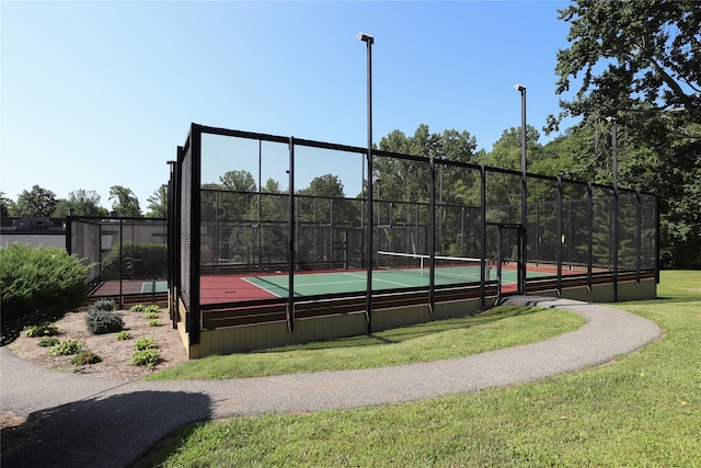 view of sport court with fence and a yard