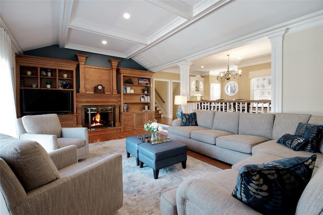 living room featuring lofted ceiling with beams, a large fireplace, ornamental molding, and decorative columns