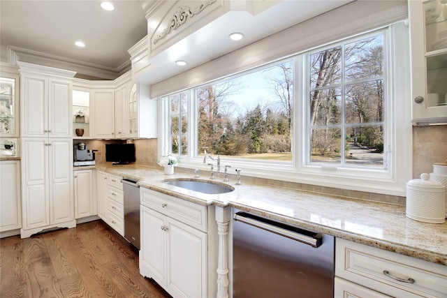 kitchen with stainless steel dishwasher, a sink, and glass insert cabinets