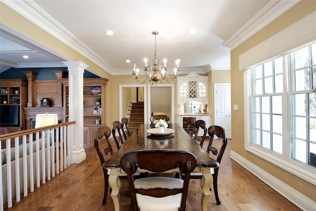 dining area featuring ornamental molding, ornate columns, and wood finished floors