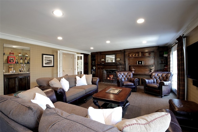 living area featuring recessed lighting, bar area, carpet flooring, a high end fireplace, and crown molding