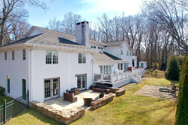 rear view of house featuring french doors, a patio, a chimney, fence, and a deck