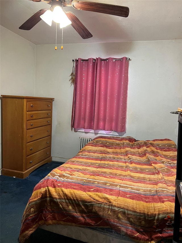 bedroom featuring radiator heating unit, dark carpet, and a ceiling fan