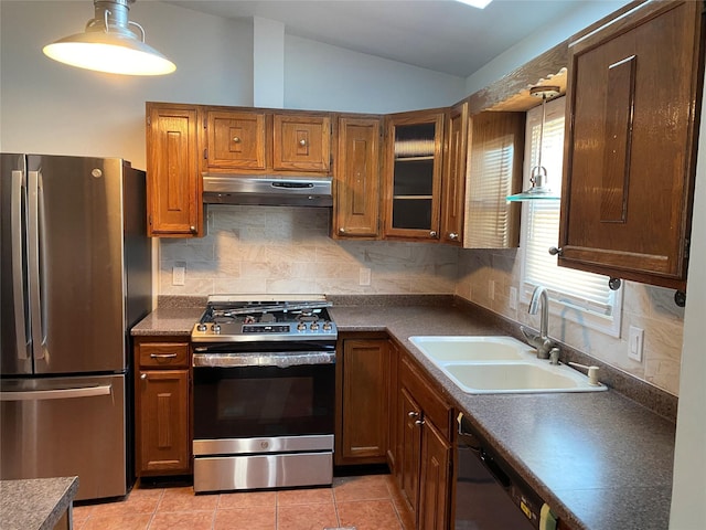 kitchen with appliances with stainless steel finishes, dark countertops, and under cabinet range hood