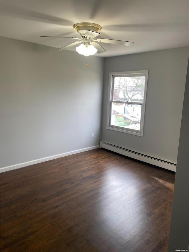 unfurnished room with a baseboard heating unit, dark wood-style flooring, baseboards, and a ceiling fan