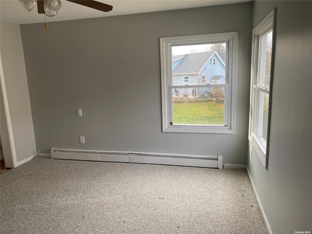 carpeted spare room featuring baseboards, a baseboard heating unit, and ceiling fan