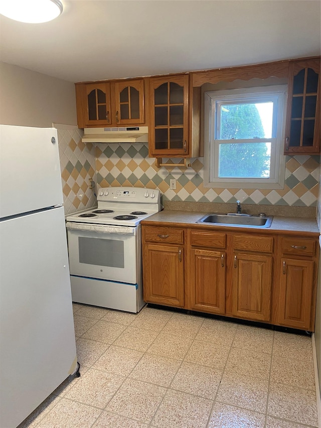 kitchen featuring white appliances, light countertops, a sink, and under cabinet range hood