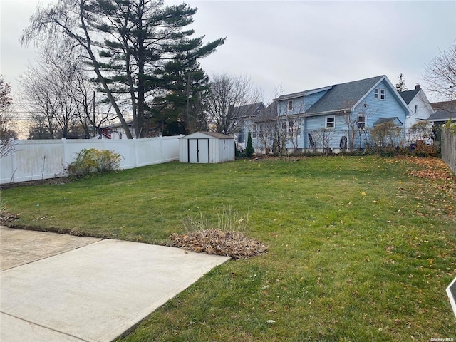 view of yard featuring a storage shed, a patio area, a fenced backyard, and an outdoor structure