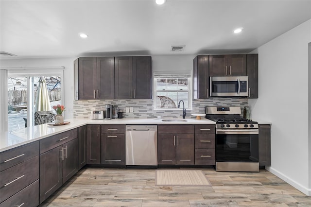 kitchen with light countertops, visible vents, appliances with stainless steel finishes, a healthy amount of sunlight, and a sink