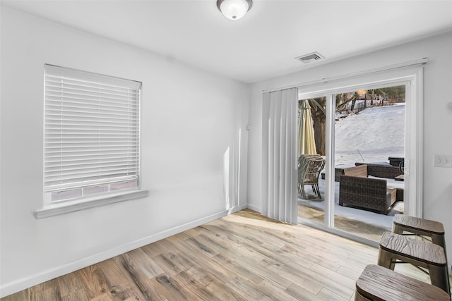 interior space with light wood-style flooring, visible vents, and baseboards