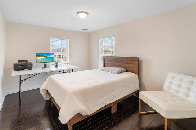 bedroom featuring baseboards, multiple windows, visible vents, and dark wood finished floors