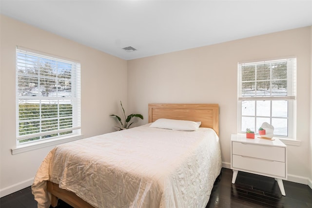 bedroom featuring visible vents, baseboards, and dark wood-style flooring