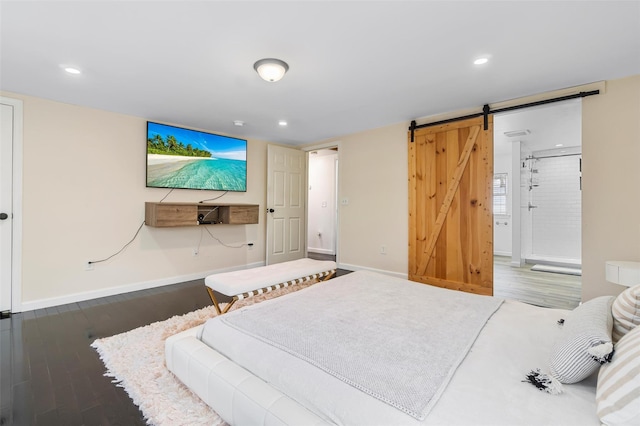 bedroom featuring dark wood-style floors, a barn door, recessed lighting, and baseboards