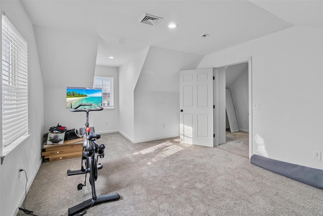 exercise room featuring recessed lighting, light colored carpet, visible vents, vaulted ceiling, and baseboards