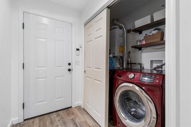 clothes washing area with light wood-type flooring, washer / clothes dryer, water heater, and laundry area