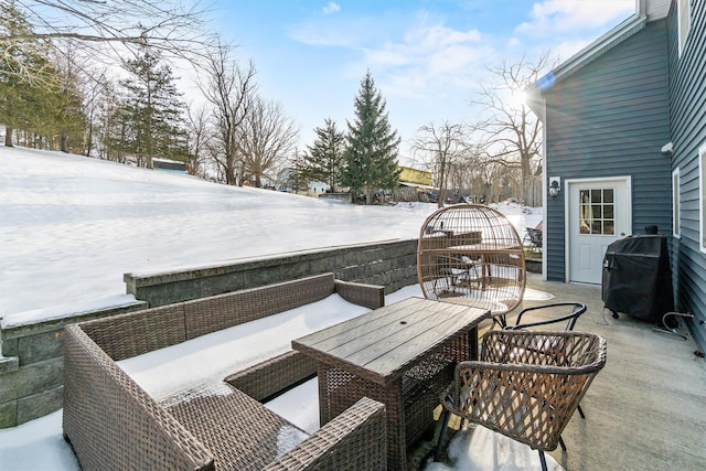 snow covered patio featuring grilling area and outdoor dining space