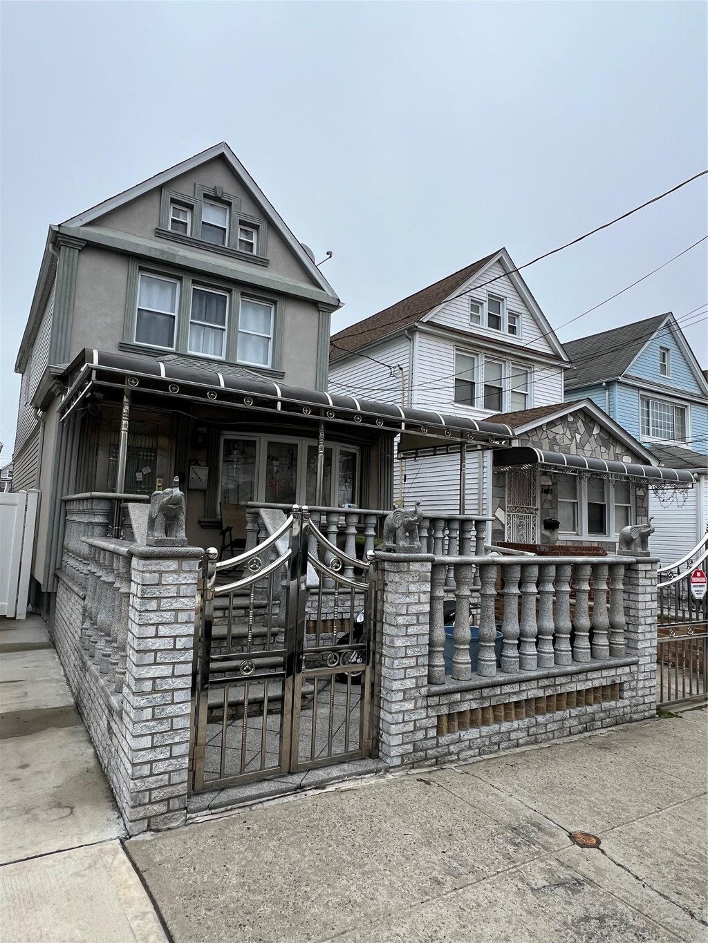 view of front facade with stucco siding and a gate