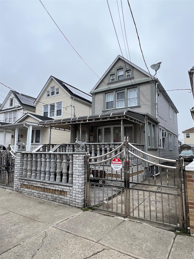 view of front of home with a fenced front yard and a gate