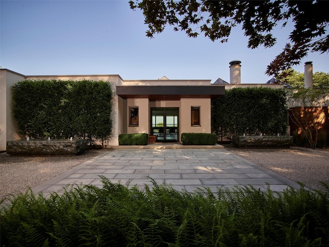 back of house with french doors, fence, and stucco siding