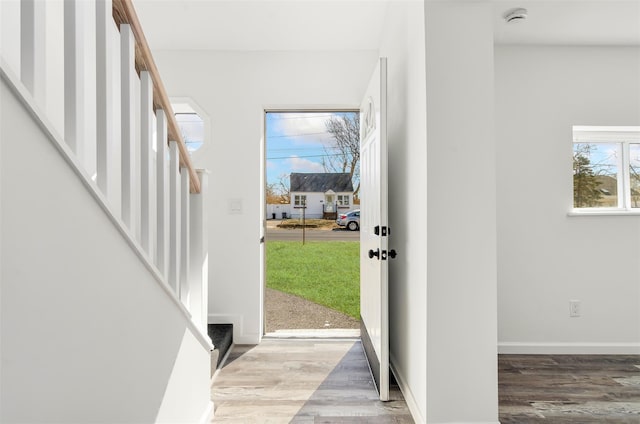 entryway featuring stairway, baseboards, and wood finished floors