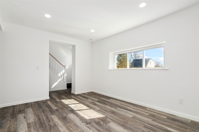 spare room with recessed lighting, stairway, baseboards, and wood finished floors