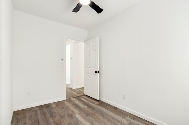 empty room featuring ceiling fan, baseboards, and wood finished floors