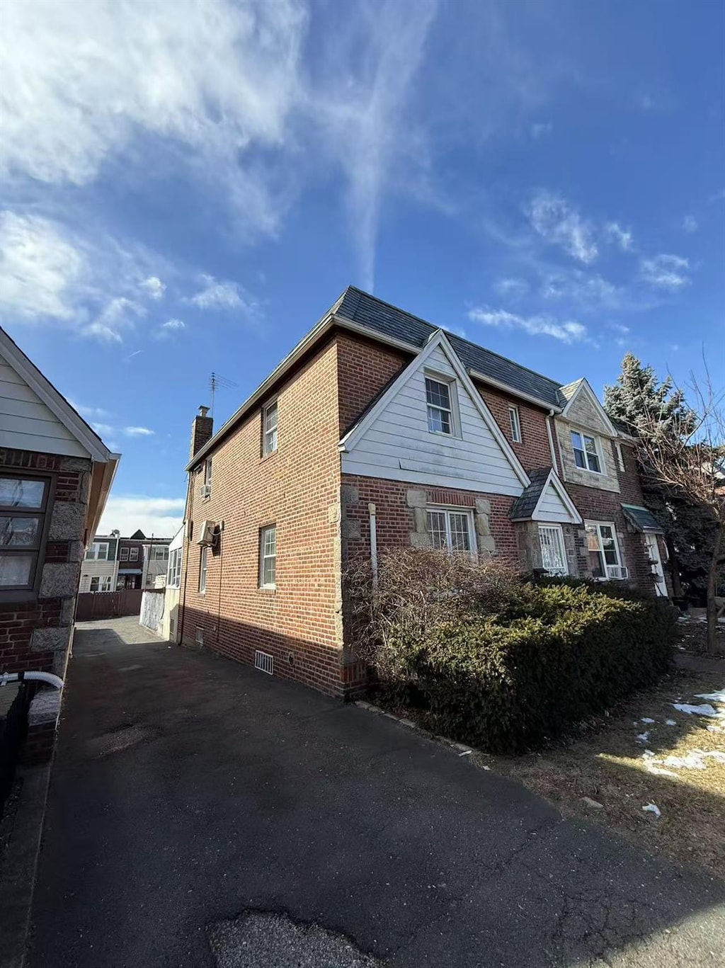 view of side of home featuring crawl space, fence, and brick siding