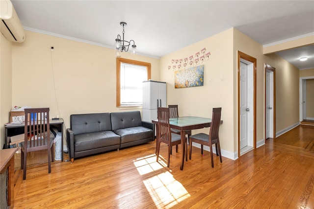 living area with baseboards, crown molding, light wood-style floors, a chandelier, and a wall mounted AC