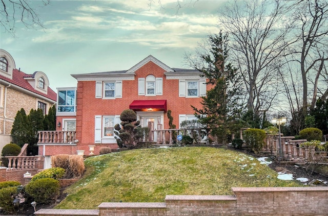 view of front facade featuring a front yard and brick siding