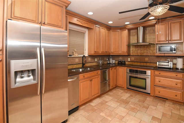 kitchen featuring dark countertops, decorative backsplash, stainless steel appliances, wall chimney exhaust hood, and a sink