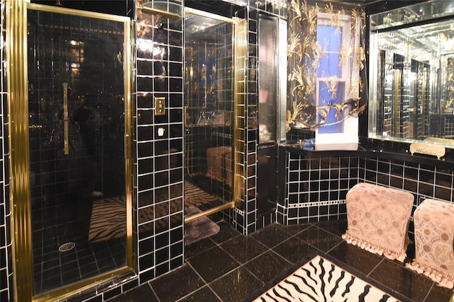 full bath with tile patterned flooring, a shower stall, and tile walls