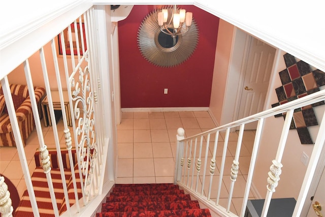 staircase with a chandelier and tile patterned flooring