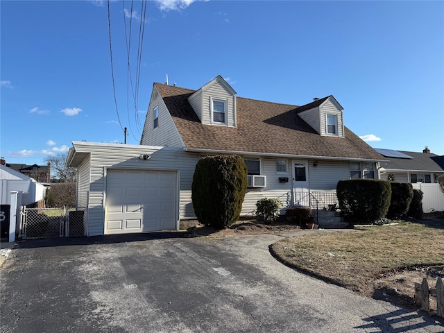 new england style home with a garage, a shingled roof, fence, and aphalt driveway