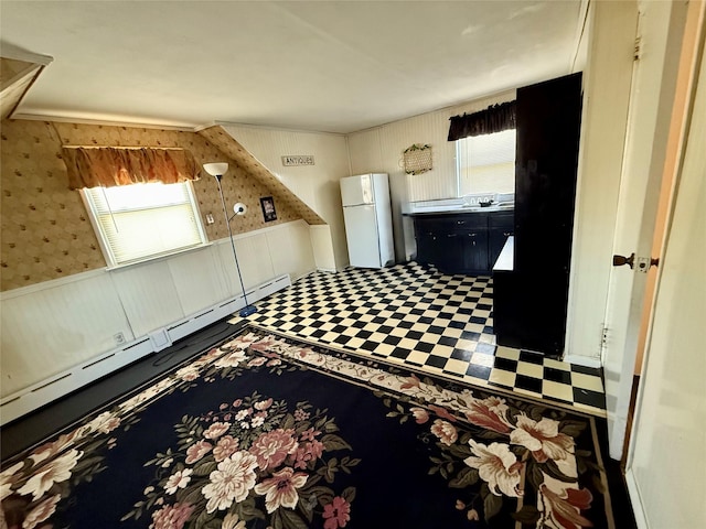 interior space featuring wallpapered walls, a baseboard radiator, a wealth of natural light, and wainscoting