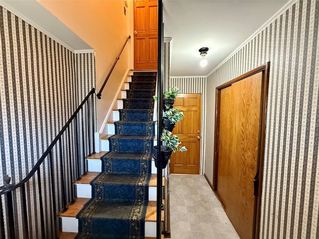 stairs featuring ornamental molding and wallpapered walls