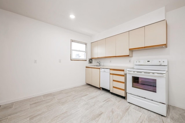 kitchen featuring light countertops, white appliances, cream cabinets, and a sink