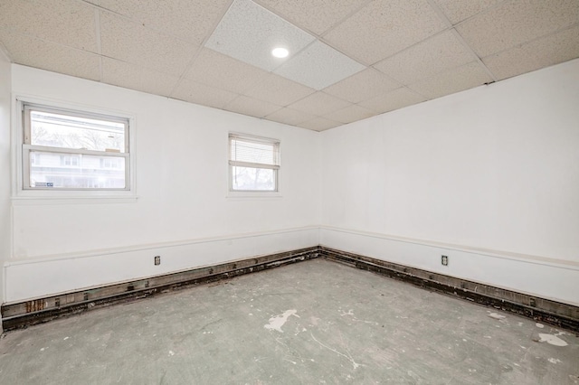 spare room with concrete floors and a drop ceiling