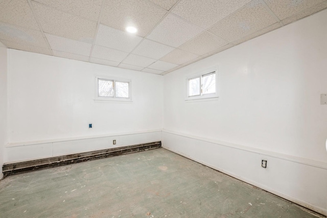 basement featuring a paneled ceiling and plenty of natural light