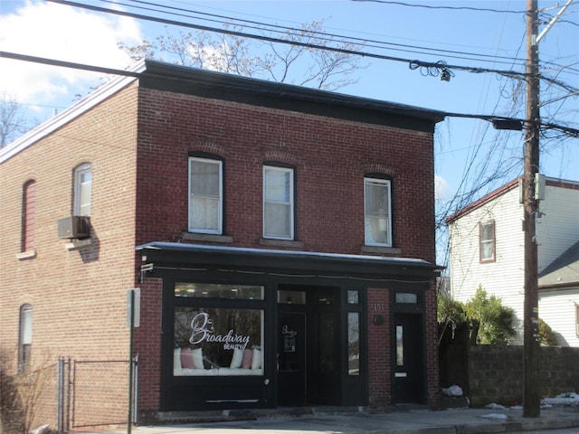 view of front facade with a gate, fence, and brick siding