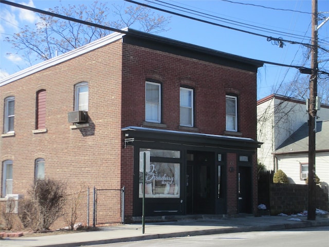 view of front of house with brick siding and fence