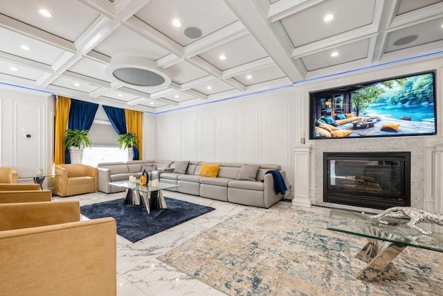 living room with a glass covered fireplace, marble finish floor, coffered ceiling, and a decorative wall