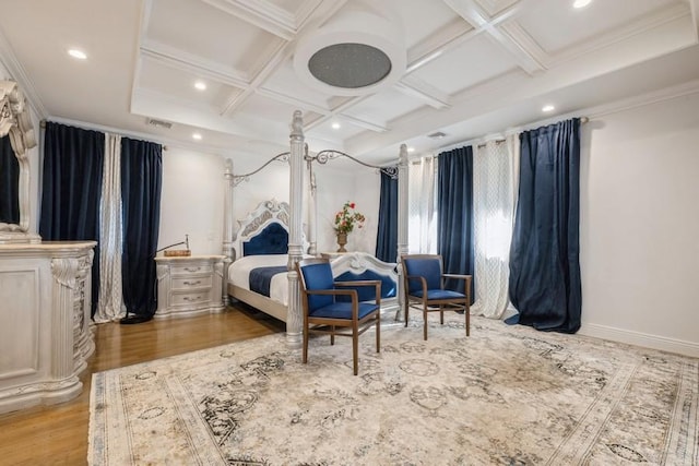 bedroom featuring coffered ceiling, crown molding, baseboards, and wood finished floors